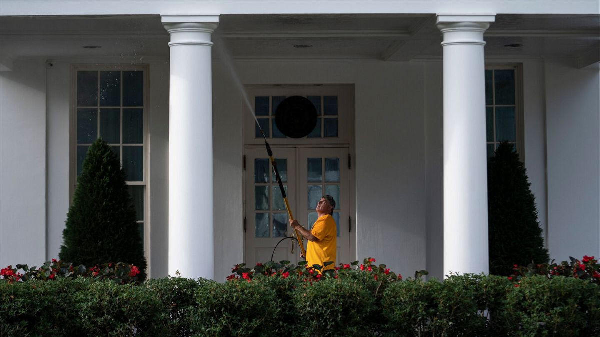 <i>Sarah Silbiger/Getty Images</i><br/>A maintenance worker power washes the West Wing of the White House on August 7.