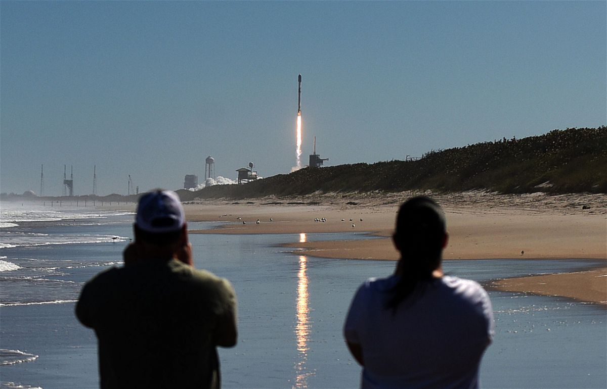 CAPE CANAVERAL, FLORIDA, UNITED STATES - 2022/02/03: People watch from Canaveral National Seashore as a SpaceX Falcon 9 rocket launches from pad 39A at the Kennedy Space Center in Cape Canaveral, Florida. 
The rocket is carrying 49 Starlink internet satellites for a broadband network. (Photo by Paul Hennessy/SOPA Images/LightRocket via Getty Images)