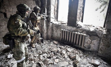 Two Russian soldiers are pictured here patrolling in the Mariupol drama theatre in Mariupol on April 12