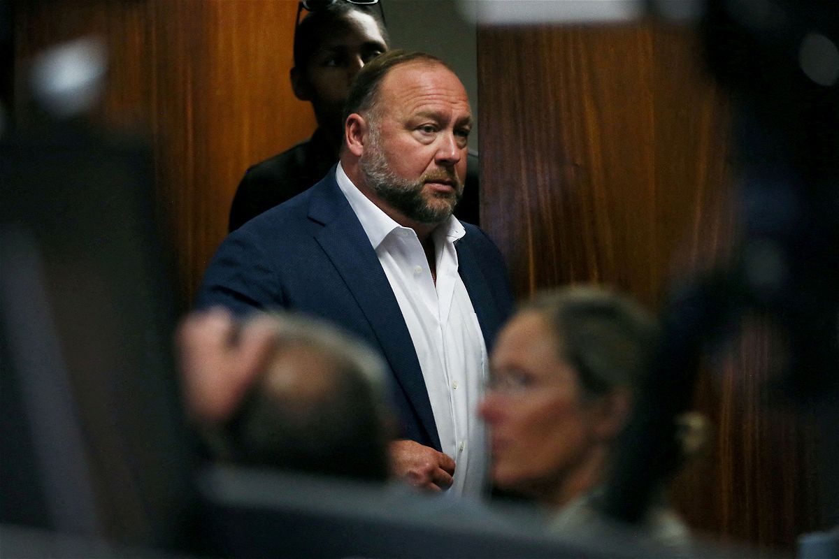 FILE PHOTO: Alex Jones walks into the courtroom in front of Scarlett Lewis and Neil Heslin, the parents of 6-year-old Sand Hook shooting victim Jesse Lewis, at the Travis County Courthouse in Austin, Texas, U.S. July 28, 2022. Jones had been found to have defamed the parents of a Sandy Hook student for calling the attack a hoax, and the parents are seeking $150 million in compensatory and punitive damages for what they say was a campaign of harassment and death threats by JonesÕ followers.    Briana Sanchez/Pool via REUTERS/File Photo/File Photo