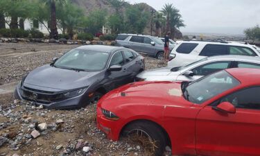 Cars are seen stuck in mud and debris at The Inn at Death Valley on August 5.