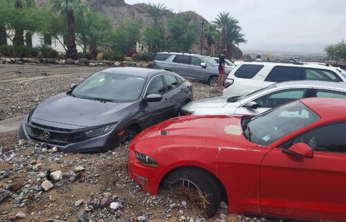 Cars are seen stuck in mud and debris at The Inn at Death Valley on August 5.