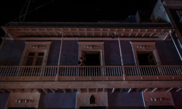 A man stands on a balcony in San Juan after a major power outage on April 6.