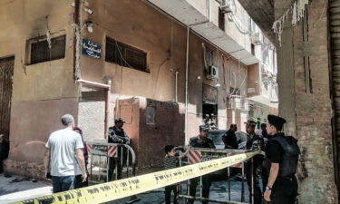 Security personnel stand at the scene where a massive fire broke out during a Sunday service at the Abu Sefein church.