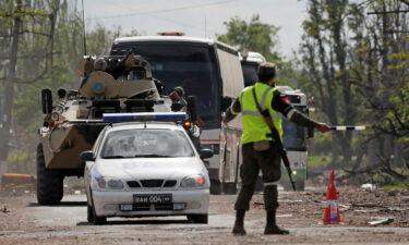 Buses carrying service members of Ukrainian forces drive away in Mariupol