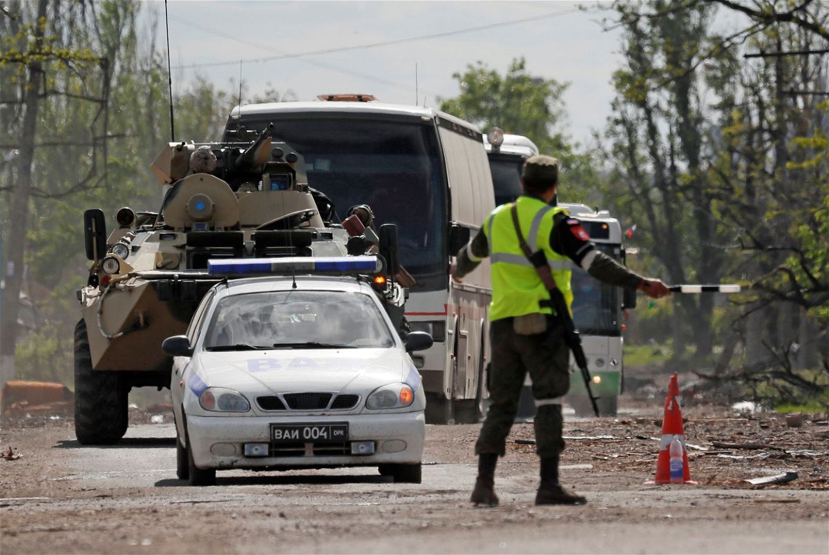 <i>Alexander Ermochenko/Reuters</i><br/>Buses carrying service members of Ukrainian forces drive away in Mariupol