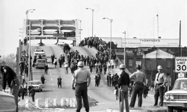 State troopers watch as marchers cross the Edmund Pettus Bridge over the Alabama River in Selma