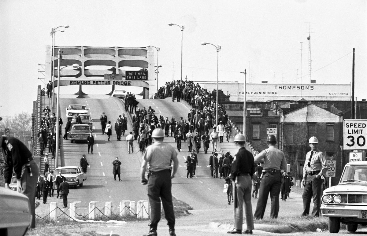 <i>Bettmann Archive/Getty Images</i><br/>State troopers watch as marchers cross the Edmund Pettus Bridge over the Alabama River in Selma