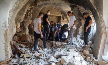 Palestinians inspect a building damaged during an Israeli military operation in Nablus on August 9.