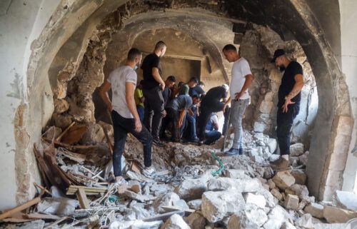 Palestinians inspect a building damaged during an Israeli military operation in Nablus on August 9.