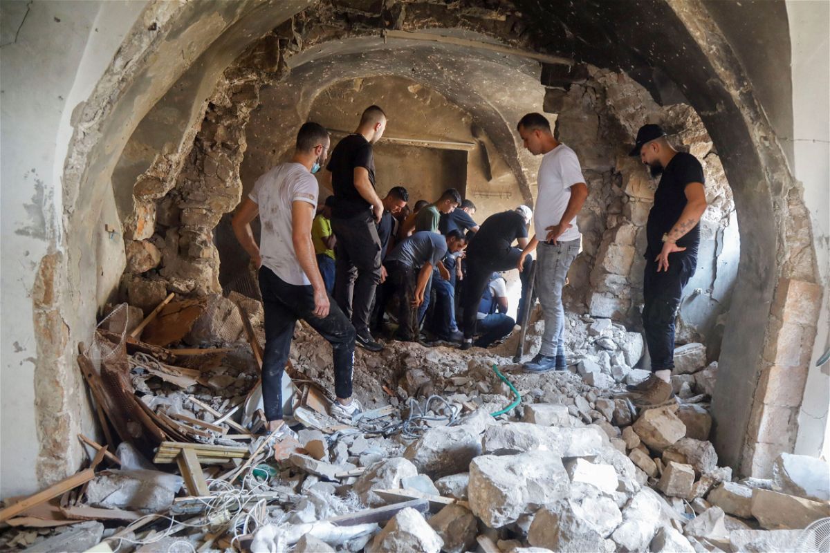 <i>Raneen Sawafta/Reuters</i><br/>Palestinians inspect a building damaged during an Israeli military operation in Nablus on August 9.