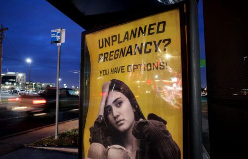 A billboard advertising adoption services targets pregnant women at a bus stop in Oklahoma City