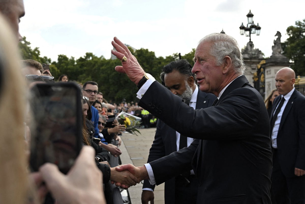 <i>Ben Stansall/AFP/Getty Images</i><br/>King Charles III greets mourners as he arrives at Buckingham Palace in London