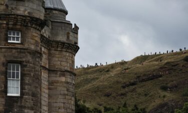 People wait for the hearse's arrival in Edinburgh.