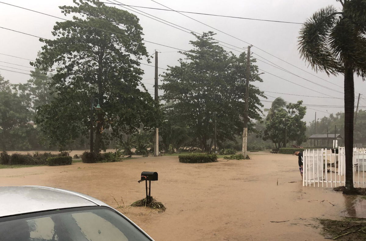 <i>Melvin Pereira/AFP/Getty Images</i><br/>A man stands near a flooded road in Villa Blanca