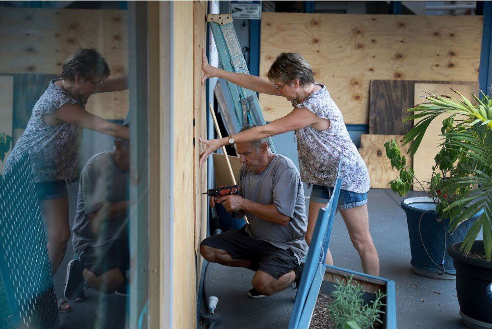 <i>Joe Raedle/Getty Images</i><br/>Frederic Herodet and Mary Herodet board up their Gulf Bistro restaurant in St. Petersburg Beach