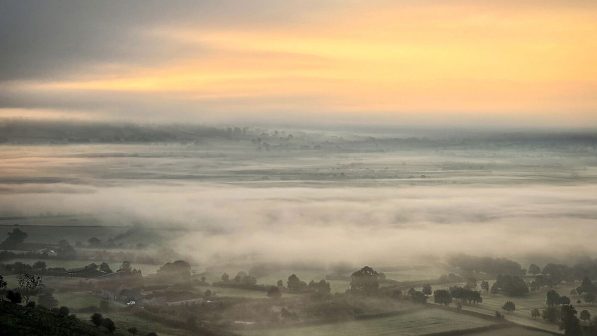 <i>Matt Cardy/Getty Images</i><br/>The rising sun tries to break through the mist near the town of Glastonbury in southwest England on fall equinox 2021.