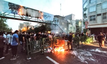 This image from outside Iran on September 21 shows Iranian demonstrators burning a trash bin in the capital Tehran during a protest for Mahsa Amini