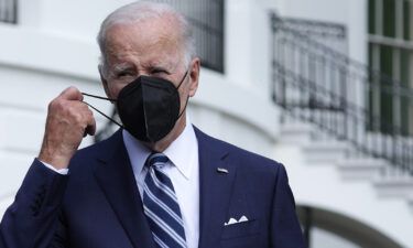 U.S. President Joe Biden takes off his mask as he walks toward members of the press on August 26 in Washington