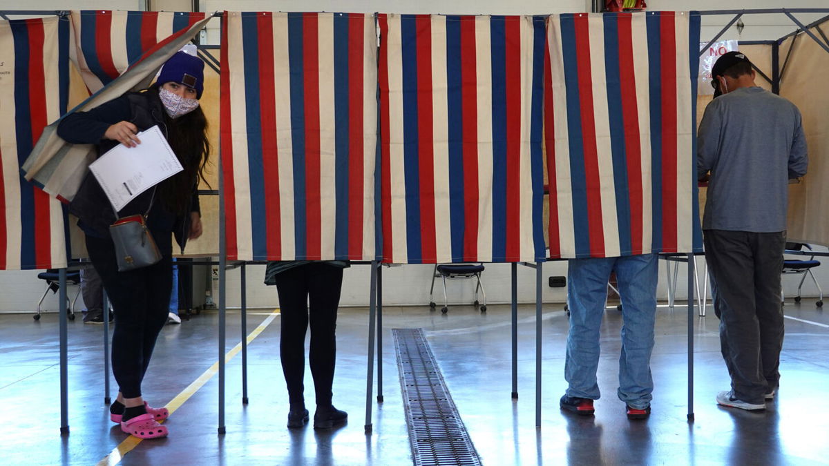 <i>Scott Olson/Getty Images</i><br/>A new book out September 20 examines how the falsehoods about election fraud in the 2020 election now threaten democracy. Residents are seen here voting at the Town of Beloit fire station in November 2020 near Beloit