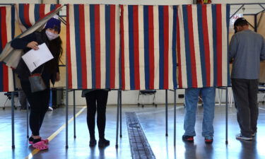 A new book out September 20 examines how the falsehoods about election fraud in the 2020 election now threaten democracy. Residents are seen here voting at the Town of Beloit fire station in November 2020 near Beloit