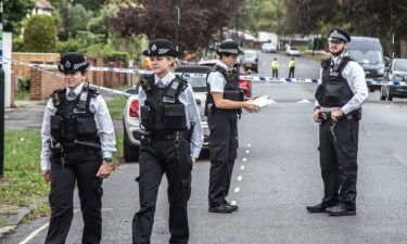 Police officers stand on guard at the crime scene in Kirkstall Gardens.