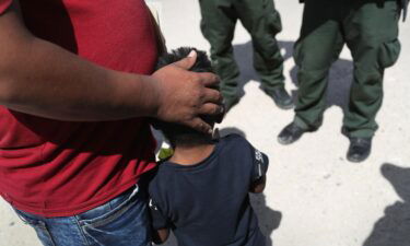 U.S. Border Patrol agents take a father and son from Honduras into custody near the U.S.-Mexico border in June 2018. The Justice Department wants a federal judge to require psychological examinations of families separated at the US-Mexico border.