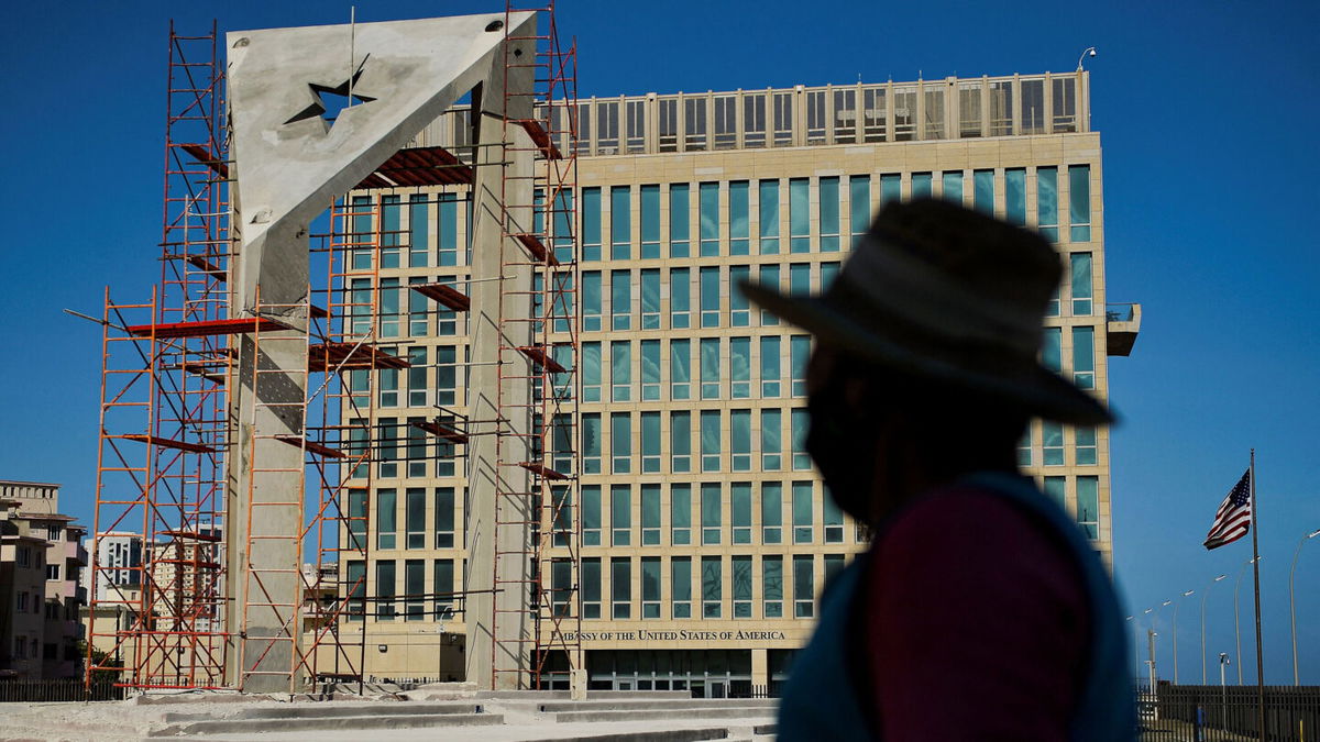 <i>YAMIL LAGE/AFP via Getty Images</i><br/>A worker looks at a huge concrete Cuban flag being build in front of the U.S. Embassy in Havana