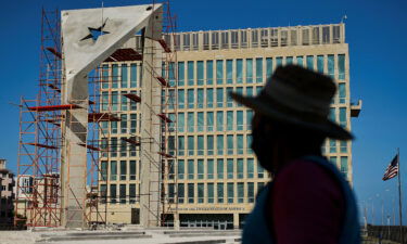 A worker looks at a huge concrete Cuban flag being build in front of the U.S. Embassy in Havana