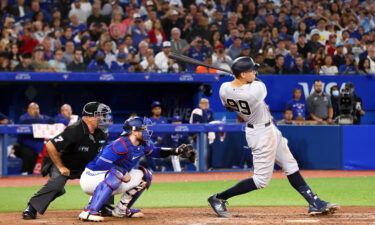 Wife of Toronto Blue Jays coach jokes about 'divorce' after watching her husband give away Aaron Judge's lucrative home run ball. Judge is pictured here hitting his 61st home run of the season.