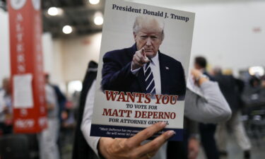 An attendee holds a sign in support of Matthew DePerno