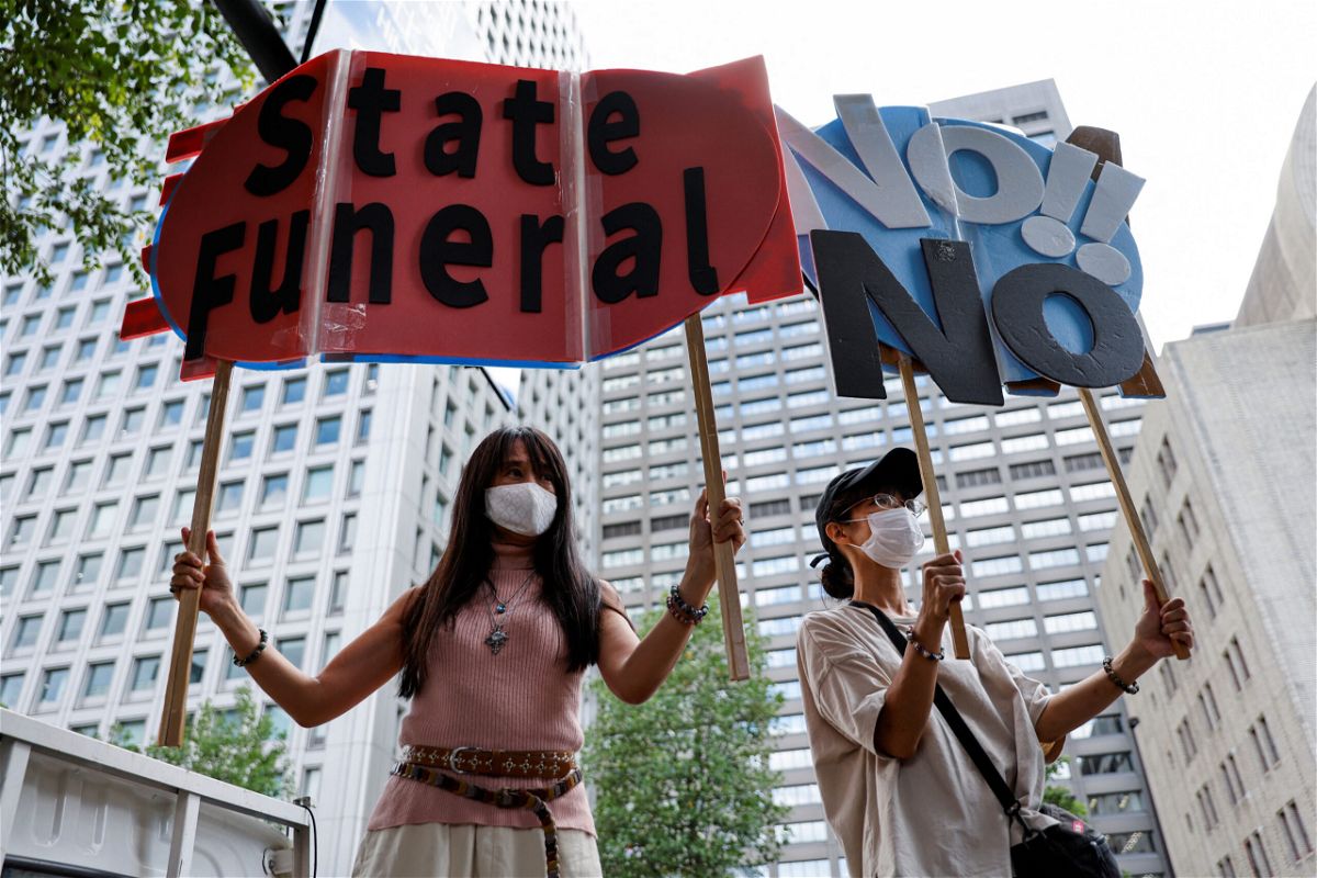 <i>Issei Kato/Reuters</i><br/>People hold up signs during a protest against Japan's state funeral for former Prime Minister Shinzo Abe in Tokyo on September 27.