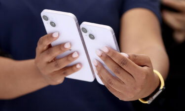 Shares of Apple fell 4% in early trading September 28 amid concerns about demand for the company's latest lineup of iPhones. An Apple employee is seen here holding a new iPhone 14 and iPhone 14 Plus during an Apple special event on September 07.