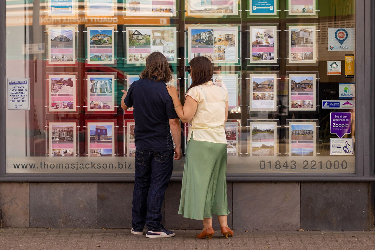 <i>Jason Alden/Bloomberg/Getty Images</i><br/>House prices in the United Kingdom could plummet by as much as 15% if the country presses ahead with its tax-slashing economic gamble. Pedestrians are seen here looking at properties listings in an estate agents window in Margate