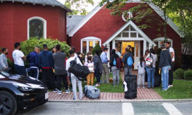 The migrants flown from Texas gather outside a church on Martha's Vineyard on September 14. The man who recruited migrants for flights to Martha's Vineyard says he feels betrayed.