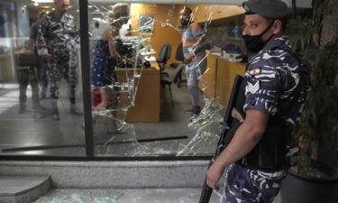 Five banks in Lebanon are held up by depositors demanding access to savings. A Lebanese policeman is pictured here standing guard next to a bank window that was broken by depositors who attacked it trying to get blocked money in Beirut on September 14.