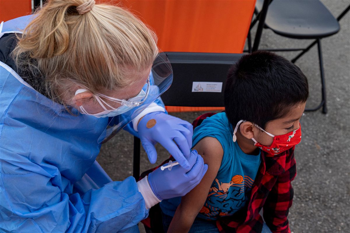 <i>David Paul Morris/Bloomberg/Getty Images</i><br/>A health care worker administers a Pfizer/BioNTech Covid-19 vaccine to a child at a vaccination site in San Francisco on January 10.