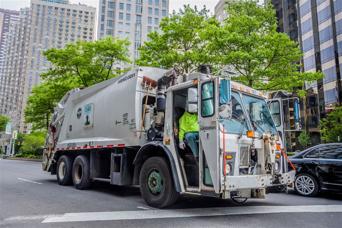 <i>Erik McGregor/LightRocket/Getty Images</i><br/>A garbage truck is pictured driving around Manhattan. New York City officials are moving to limit the number of hours residential and commercial trash can sit on the curb before it's picked up.