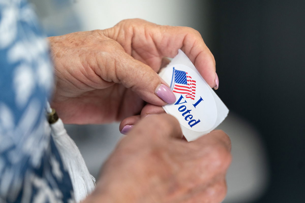 <i>Sean Rayford/Getty Images</i><br/>Election deniers are running for important offices around the country in the November 8 midterms and pictured a poll worker holds a sticker that reads