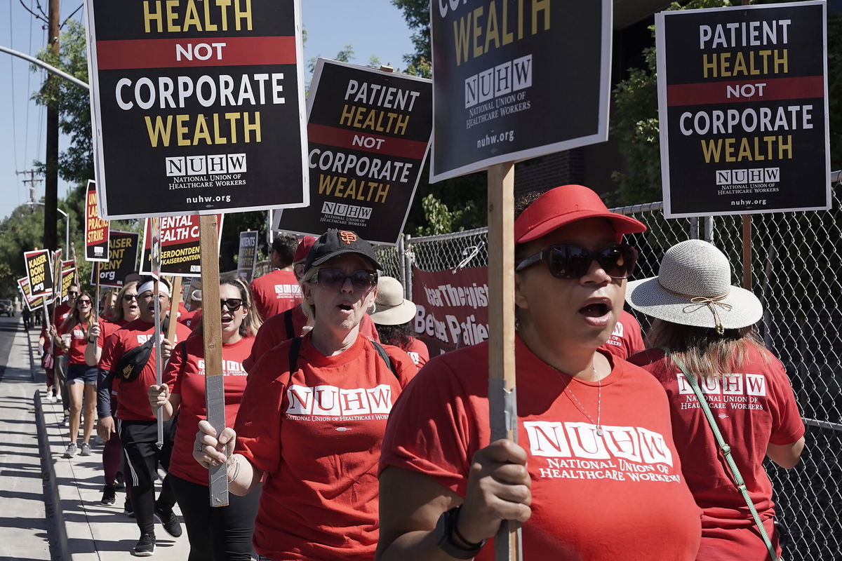 <i>Rich Pedroncelli/AP</i><br/>California mental health workers vote Friday to end the 10-week strike. Kaiser Permanente mental health workers and supporters here march outside a Kaiser facility in Sacramento