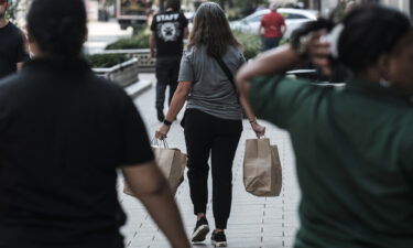 Most corporate economists believe the United States is already in a recession. A shopper here carries bags in Detroit