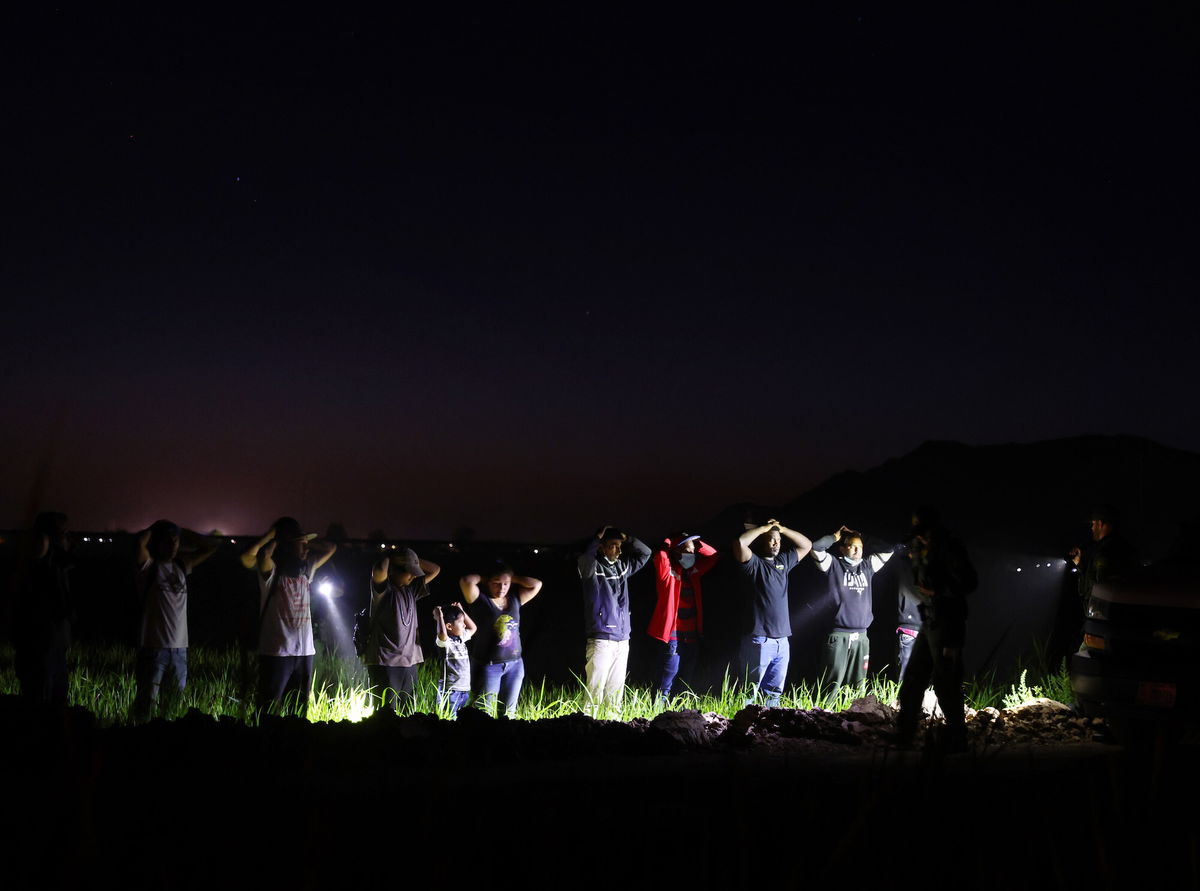 <i>Mario Tama/Getty Images</i><br/>Migrants are detained by U.S. Border Patrol agents on May 22 in Yuma