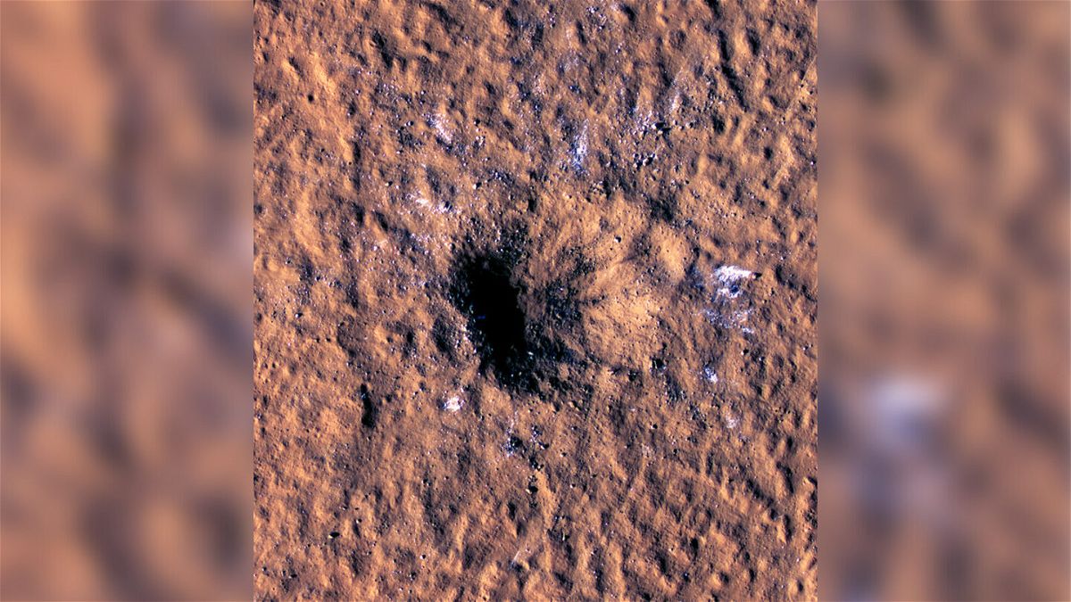 <i>NASA/JPL-Caltech/University of Arizona</i><br/>Ice chunks glimmer around the rim of a newly formed crater on Mars.