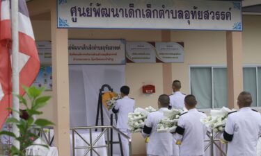 A Thai officer lays a wreath of flowers from the royal family to mourn those killed at a child care center in the country's north.