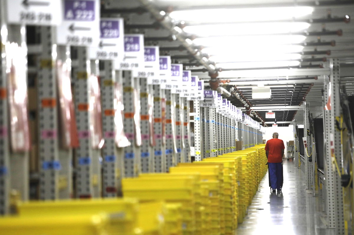 <i>Genaro Molina/Los Angeles Times/Getty Images</i><br/>A worker transports plastic crates filled with orders to be shipped to customers at the Amazon Fulfillment Center in Moreno Valley