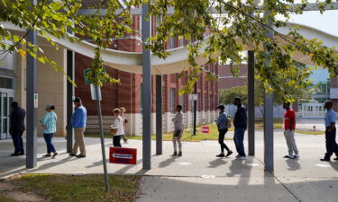 A line of early voters stretches outside the building as early voting begins for the midterm elections at the Citizens Service Center in Columbus