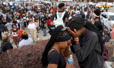 Students stand in a parking lot near the Central Visual & Performing Arts High School after the shooting.