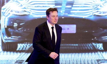 Tesla Inc CEO Elon Musk walks next to a screen showing an image of Tesla Model 3 car during an opening ceremony for Tesla China-made Model Y program in Shanghai