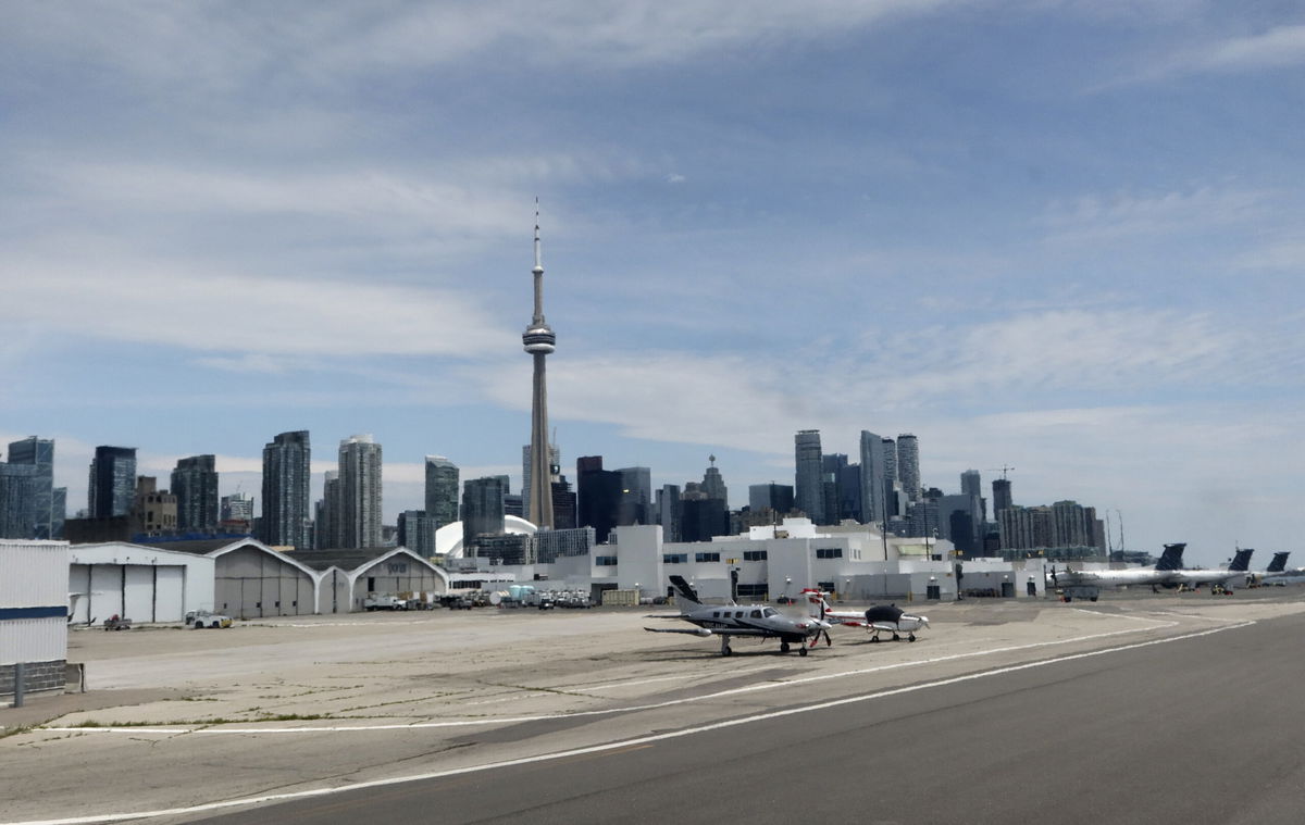 <i>Gary Hershorn/Corbis News/Getty Images</i><br/>Airplanes sit on the tarmac at Billy Bishop Toronto City Airport in front of the CN Tower on July 4