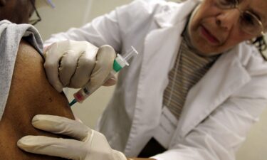 Flu season has ramped up early in the United States and flu hospitalizations are worse than usual for this time of year. Robert Garner (left) receives a flu shot from registered nurse Betty Lewis in 2006 in Chicago.